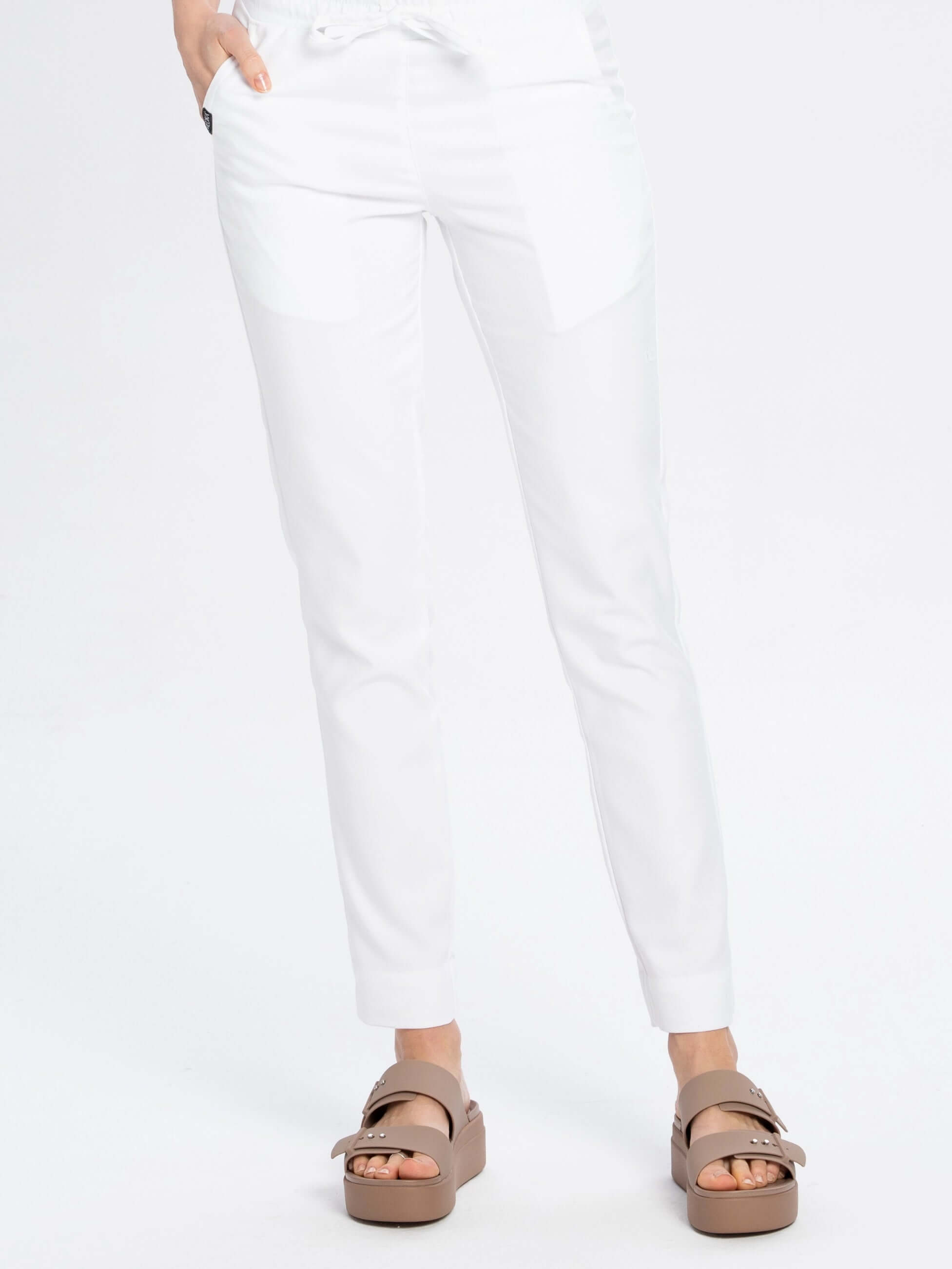 Buty medyczne Crocs Brooklyn latte i białe spodnie